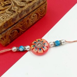 ARNAS 1 PC PEACH ROUND MOTIF STONE WITH WHITE & BLUE LOOK ALIKE PEARL DESIGNER RAKHI